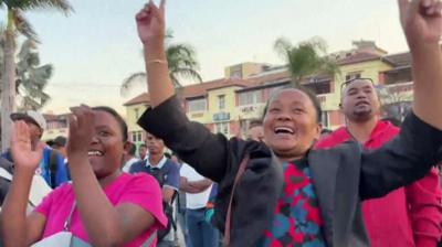 Women with raised arms, cheering in a crowd