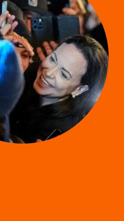 Nobel Peace Prize winner María Corina Machado hugging and smiling with supporters outside the Grand Hotel in Oslo