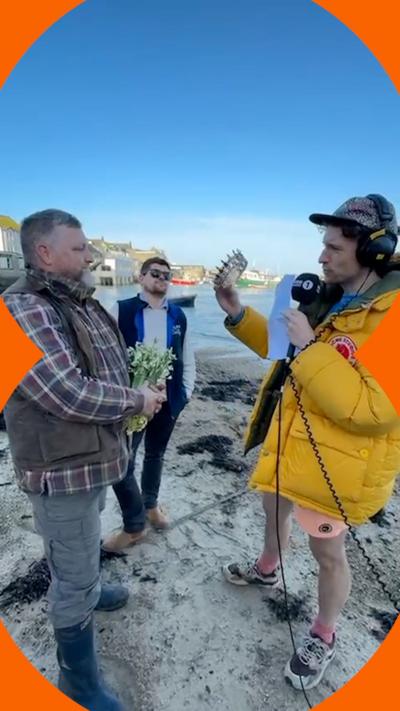 Greg from Radio 1 with the two contestants standing and looking at a tiara