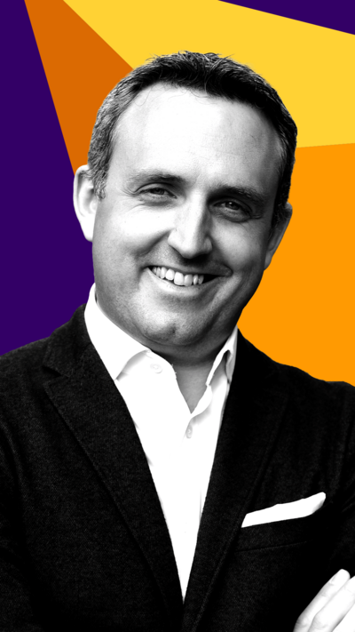 Scottish Liberal Democrat leader Alex Cole-Hamilton smiles at the camera. He is wearing a suit jacket and shirt.