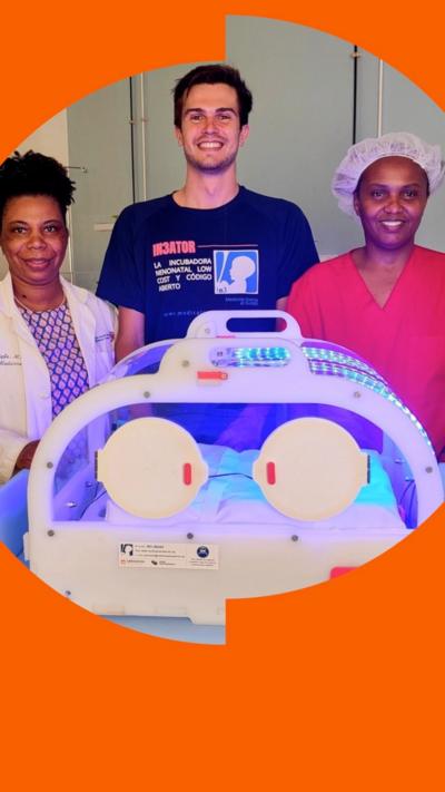 Pablo Bergasa, standing in front of his low cost incubator with two medical staff, all smiling.