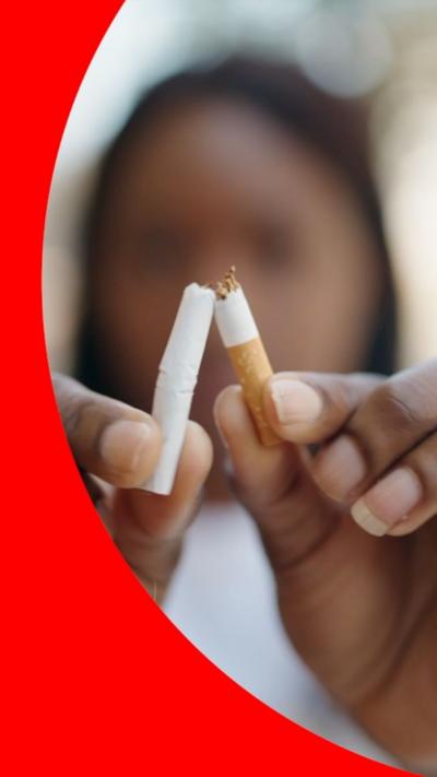 A woman breaks a cigarette in half.