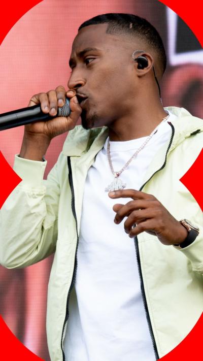 Yung Filly performing in a white t shirt and cream jacket