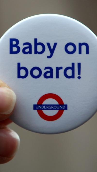 A white button badge with the words "Baby on board!" in blue, written above the London Underground logo.