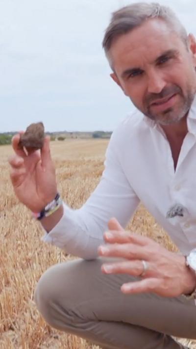 Tomos Morgan holding dirt in a field
