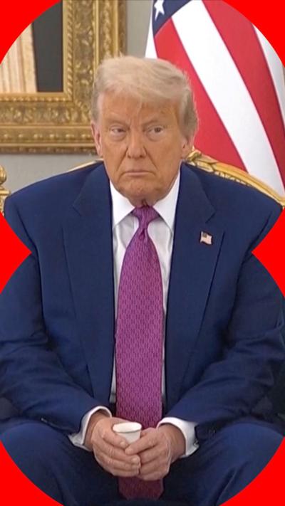 Donald Trump sat on ornate chair holding a small cup