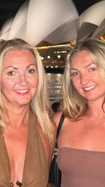 Two woman with blonde hair standing in front of Sydney Opera House
