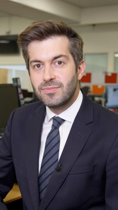 Joe Pike in a black suit and grey striped tie
