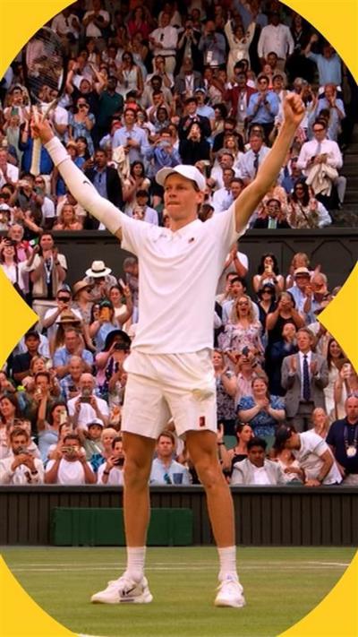 Jannik Sinner holds his hands up in celebration after winning the final. He is wearing a white cap, white polo t-shirt and white shorts. 