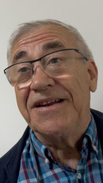 Martin Terry wearing a blue plaid shirt. He has grey hair and is wearing glasses.