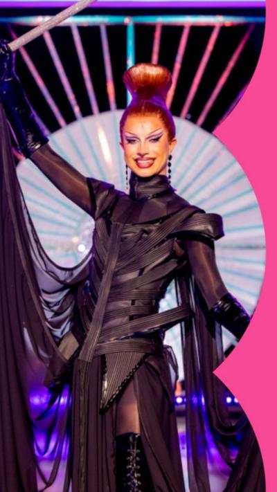 Drag Queen Bones, wearing black and a top knot, on the finale stage.