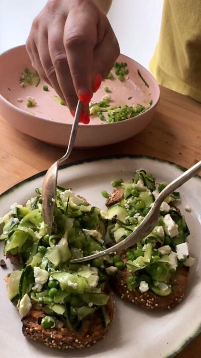 Elly spooning the courgette salad onto the toast