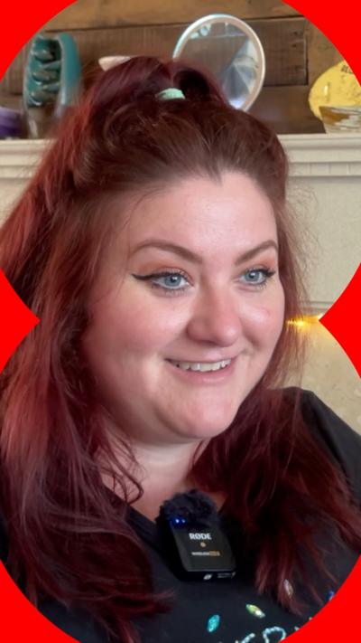 Amy Bamford smiles at the camera. She wears a black top.