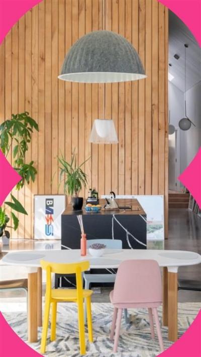 A bright kitchen and living room space which has white walls and a wooden feature wall.