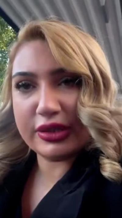 A woman with blonde hair and a black top looking at the camera.