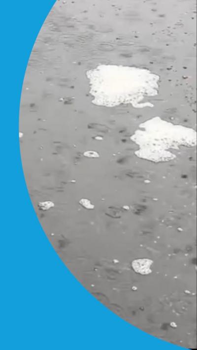 Two cloud-like areas in a puddle on a. road.