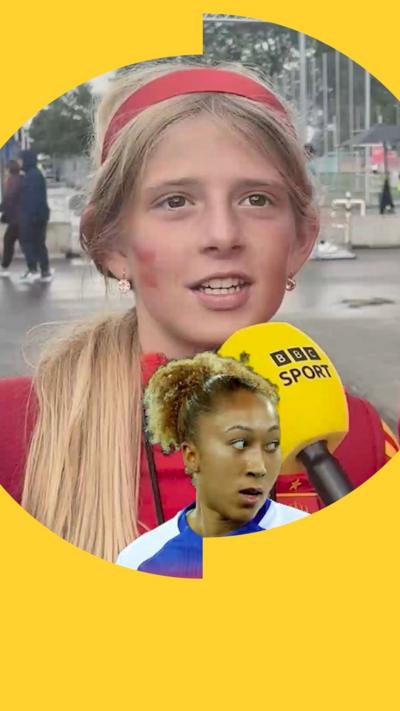 A young Spain fan, with long blonde hair and a red headband, speaking into BBC Sport microphone.
