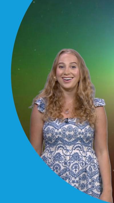 Sophia Herod stands in front of an image of a space rainbow