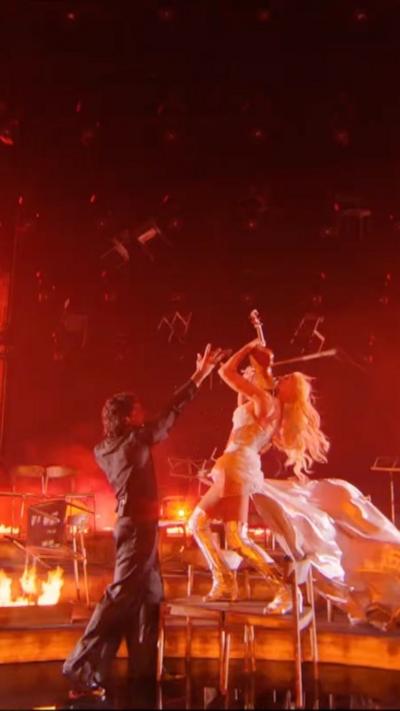 Finland's entry on stage playing a violin surrounded by fire 