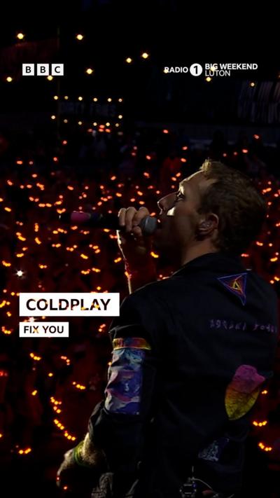 Coldplay at Radio 1 Big Weekend festival. The stage is lit up with colour.