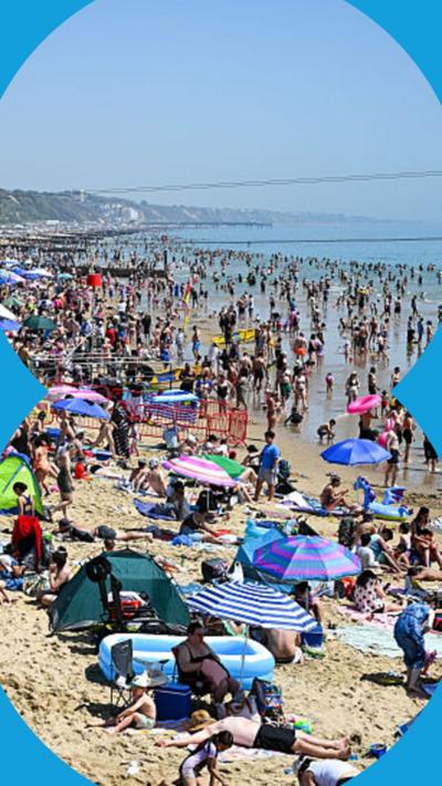 A packed UK beach in the sun.