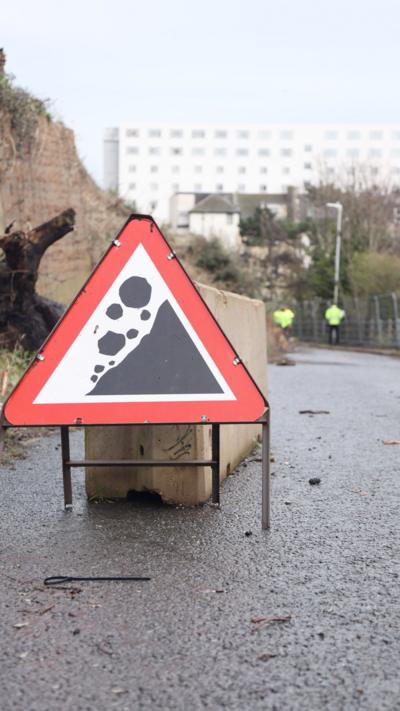 A sign warning of crumbling rocks.