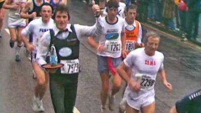 Runners taking part in the first London Marathon, including one runner dressed as a waiter carrying a drinks tray.