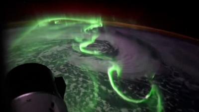 Green southern lights seen above earth from space.