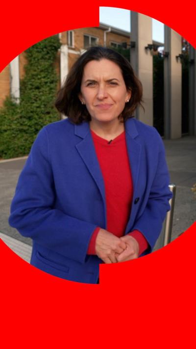 Katy Watson in a blue blazer and red top outside the courthouse