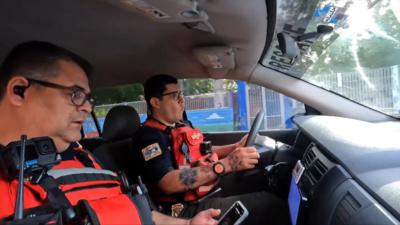 The two paramedics both wearing red stab vests and cameras, in their ambulance, on their way to an incident