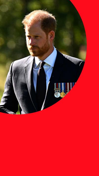 A man with short ginger hair and a short ginger beard wearing a suit and medals