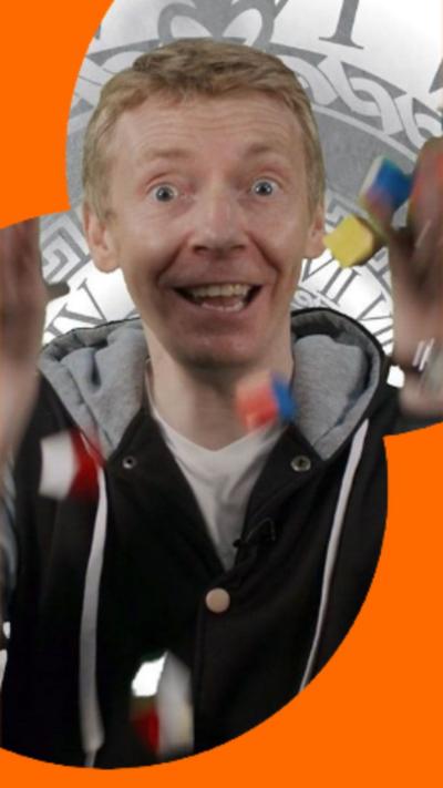 Presenter James Grime throwing a bunch of coloured wooden blocks in the air