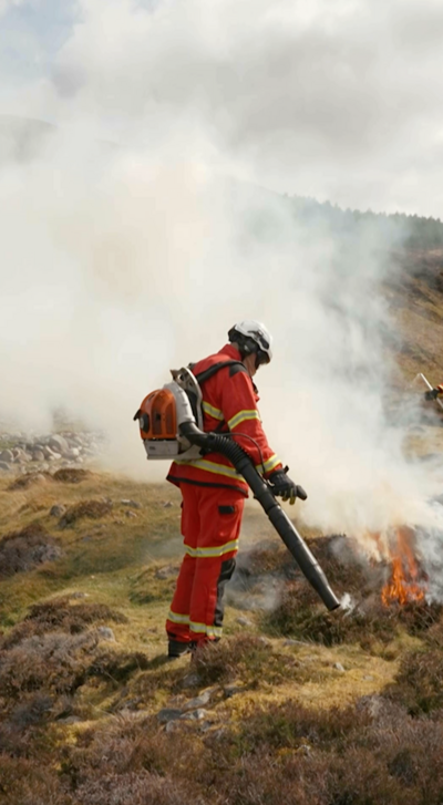 A firefighter in Scotland's countryside putting out fire
