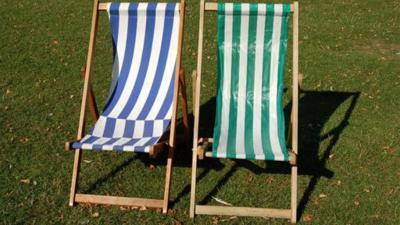 Two beach chairs. One is blue and white. The other one is green and white