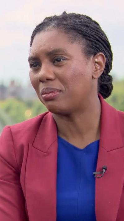 Kemi Badenoch in a maroon jacket and blue top