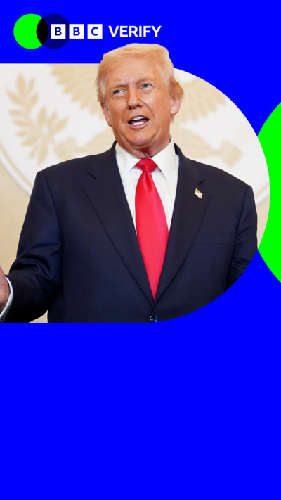 US President Donald Trump speaking. He is imposed over the BBC Verify branding and colours. He is wearing a dark suit with a red tie and American flag pin. 