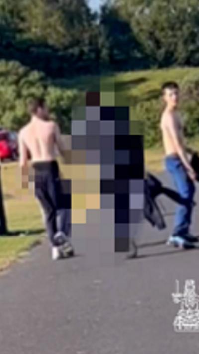 CCTV of three teens in a park, two are shirtless, the middle person is pixelated