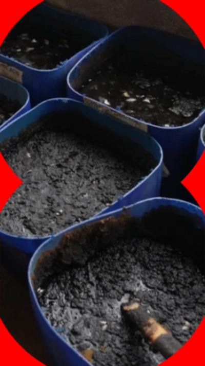 Black buckets filled with dark mud-like substance