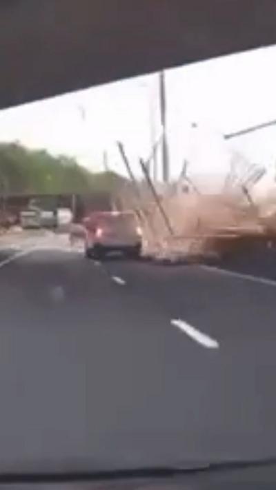 A lorry driver has died in a crash that saw his load of timber tumble down from a motorway bridge onto the M8 in Glasgow.