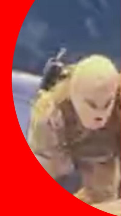 Masked men in beige fatigues climb up a ladder on the side of a ship.