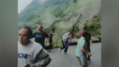 People seen running from a landslide is triggered by heavy rain in southern China