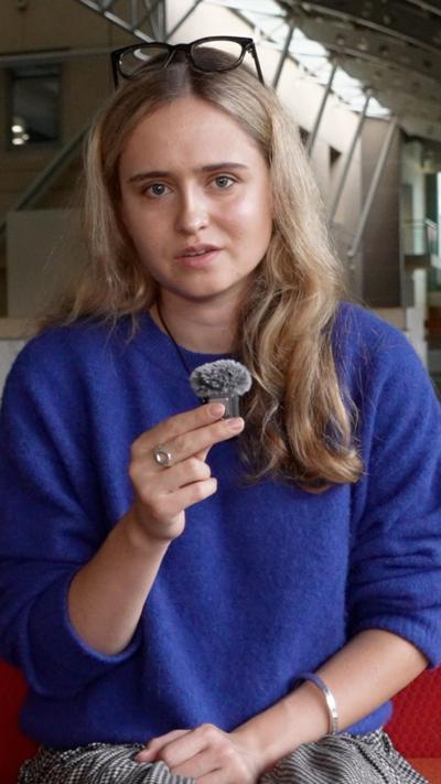 Woman wearing blue jumper sitting on red couch