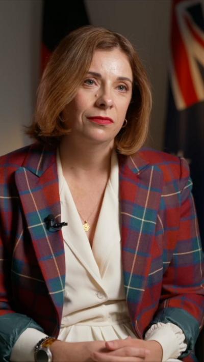 Close-up shot of Anika Wells wearing a plaid jacket