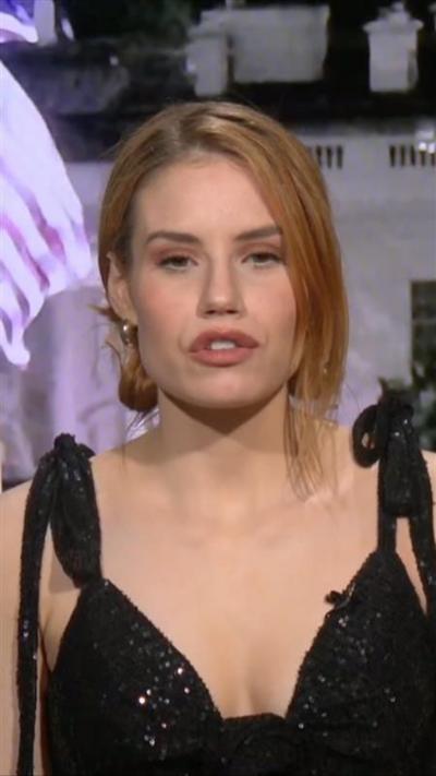 Reingold speaking in front of a live photo of The White House