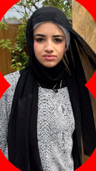 Razan, in a black head scarf, stands in her back garden surrounded by compost, seed trays and cannabis growing detritus