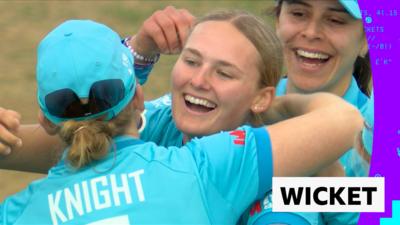 Tilly Corteen-Coleman smiling and being hugged by team-mate Heather Knight