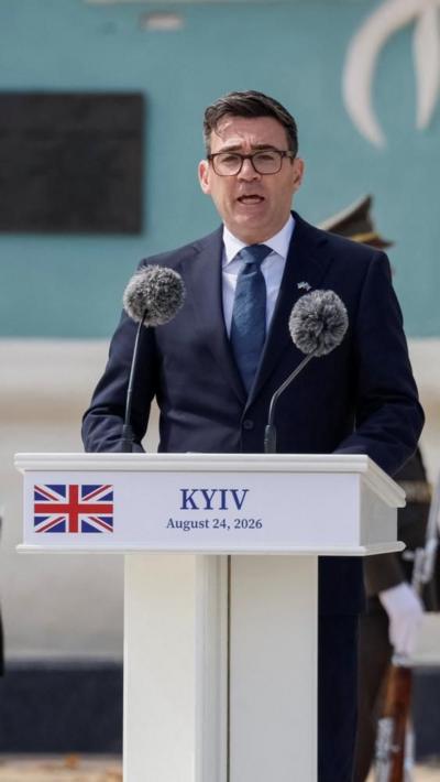 Burnham speaks at a podium