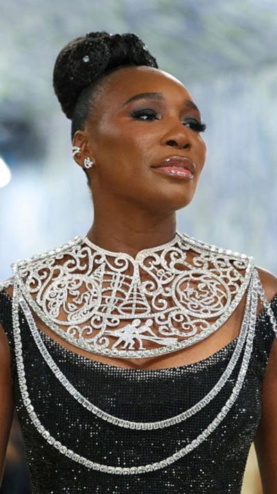 Venus Williams wears a black gown sparkly gown with a bedazzled neck piece while at the Met Gala red carpet.