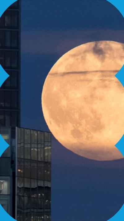 Full moon seen between two buildings in London in 2024