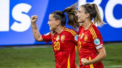 Claudia Pina (L) celebrates scoring the 2-0 goal with her teammate Alexia Putellas, both wearing red and yellow kits
